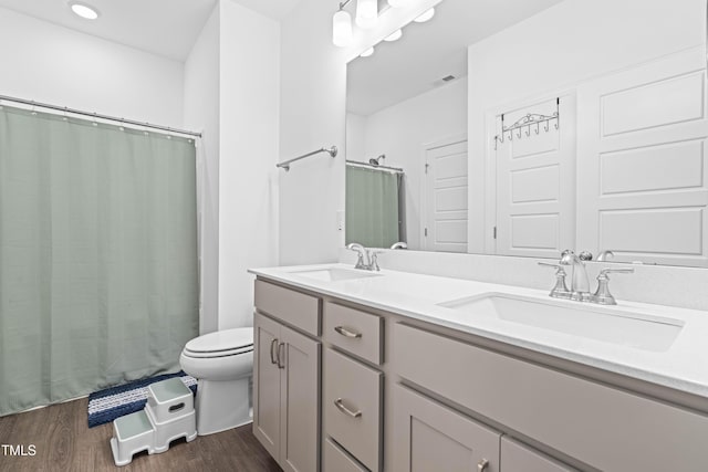 bathroom featuring vanity, hardwood / wood-style flooring, and toilet