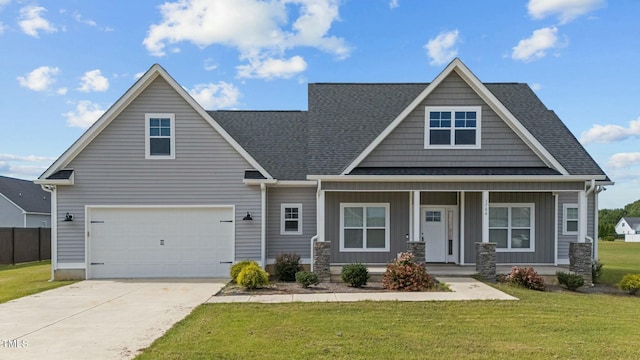 craftsman inspired home with a porch, a garage, and a front lawn