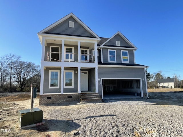 view of front facade featuring a balcony, a garage, and covered porch