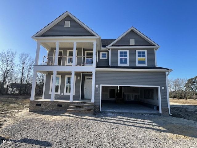 view of front of property featuring a garage, a balcony, and covered porch