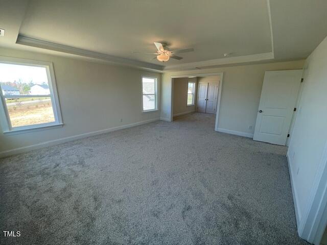 85 N Stagecoach Dr, Wendell, NC 27591 - unfurnished bedroom with a raised ceiling, baseboards, light carpet, and ceiling fan