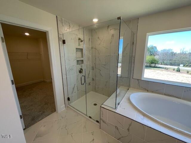 85 N Stagecoach Dr, Wendell, NC 27591 - bathroom with a garden tub, a shower stall, a walk in closet, marble look tile flooring, and recessed lighting