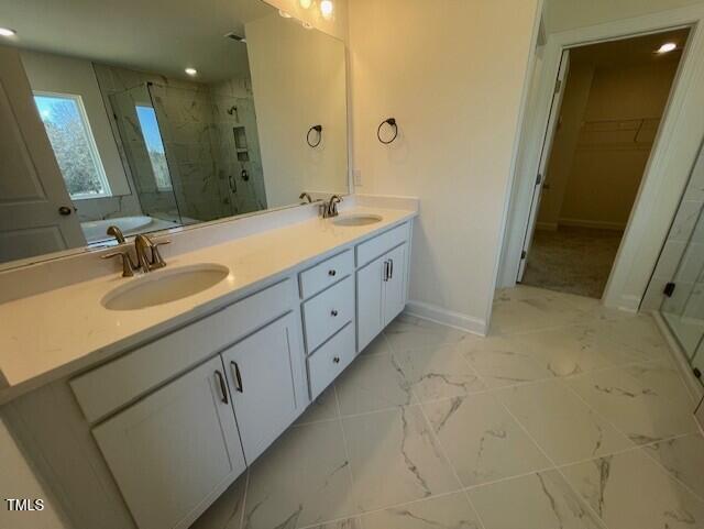 85 N Stagecoach Dr, Wendell, NC 27591 - bathroom featuring a shower stall, baseboards, double vanity, marble look tile flooring, and recessed lighting
