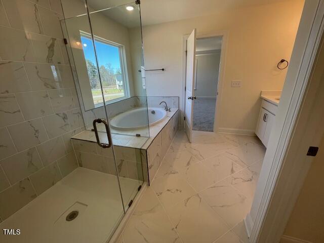85 N Stagecoach Dr, Wendell, NC 27591 - full bathroom with a bath, a shower stall, marble finish flooring, baseboards, and vanity