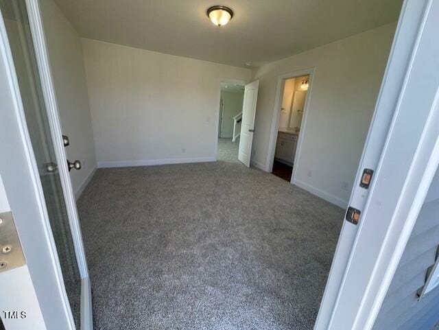 85 N Stagecoach Dr, Wendell, NC 27591 - unfurnished bedroom with carpet flooring, baseboards, and ensuite bathroom