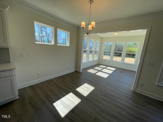85 N Stagecoach Dr, Wendell, NC 27591 - unfurnished dining area with a chandelier, healthy amount of natural light, baseboards, dark wood-type flooring, and crown molding