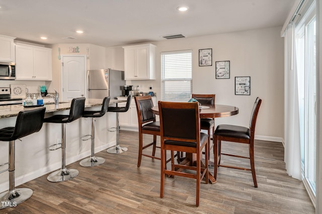 dining area with sink and wood-type flooring