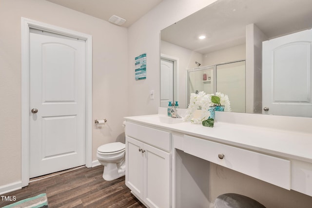 bathroom featuring hardwood / wood-style flooring, vanity, toilet, and a shower with door