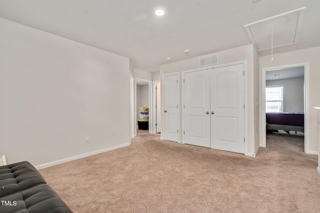 unfurnished bedroom with light carpet and a closet