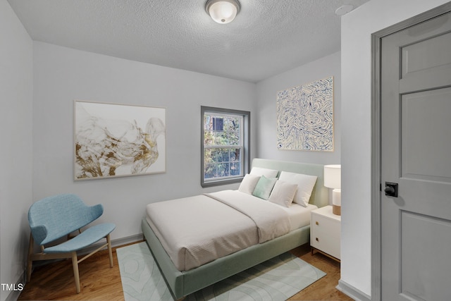 bedroom featuring wood-type flooring and a textured ceiling