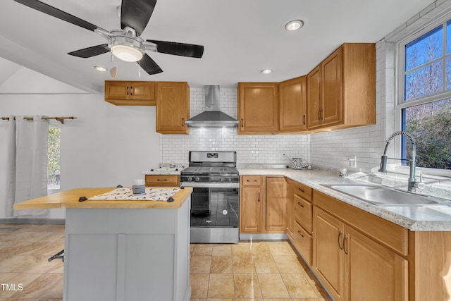 kitchen featuring stainless steel range, wall chimney exhaust hood, sink, wooden counters, and decorative backsplash