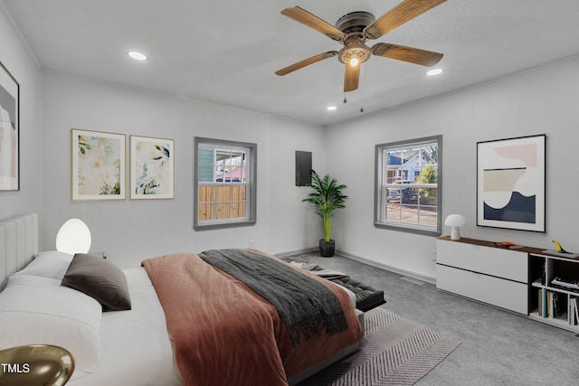 bedroom featuring ceiling fan, light carpet, and multiple windows