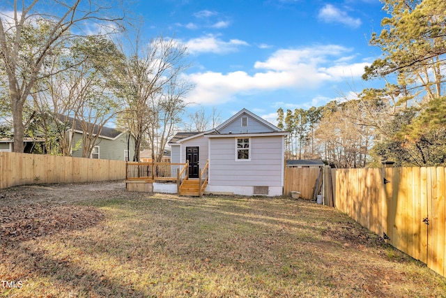 back of property featuring a wooden deck and a lawn