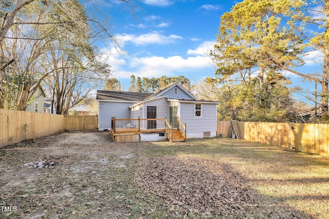 rear view of house featuring a yard and a deck