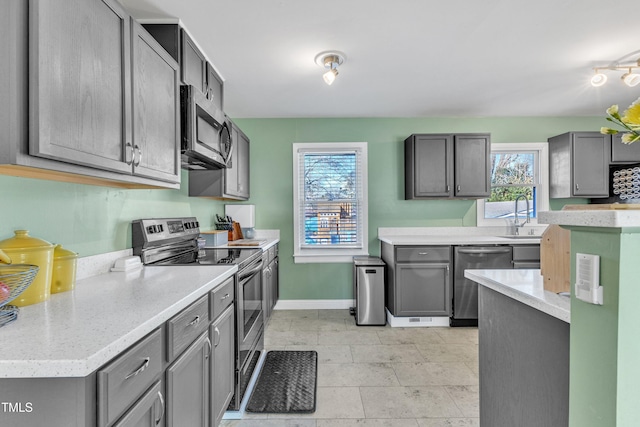 kitchen with gray cabinetry, sink, and appliances with stainless steel finishes