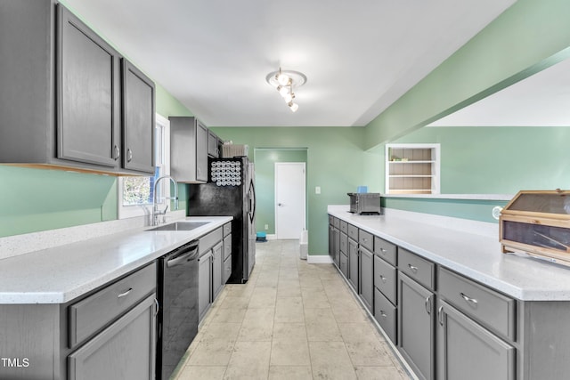 kitchen featuring stainless steel dishwasher, gray cabinets, and sink