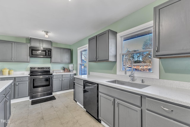 kitchen featuring gray cabinets, sink, and appliances with stainless steel finishes