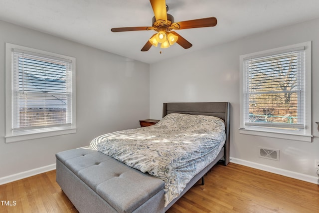 bedroom featuring multiple windows, ceiling fan, and light hardwood / wood-style floors