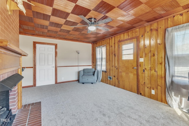 unfurnished room featuring carpet flooring, ceiling fan, a fireplace, and wood ceiling