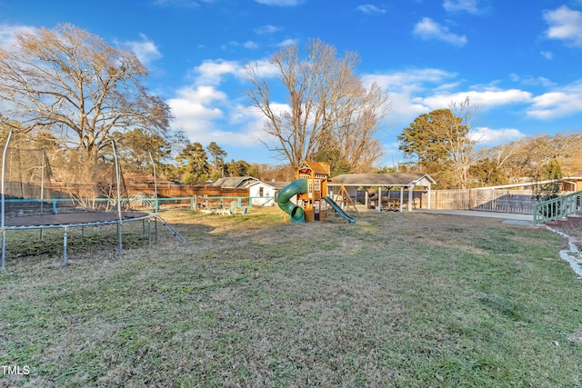 view of yard with a playground and a trampoline