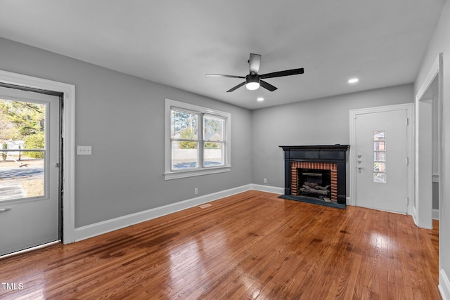 unfurnished living room featuring hardwood / wood-style flooring, a fireplace, and ceiling fan