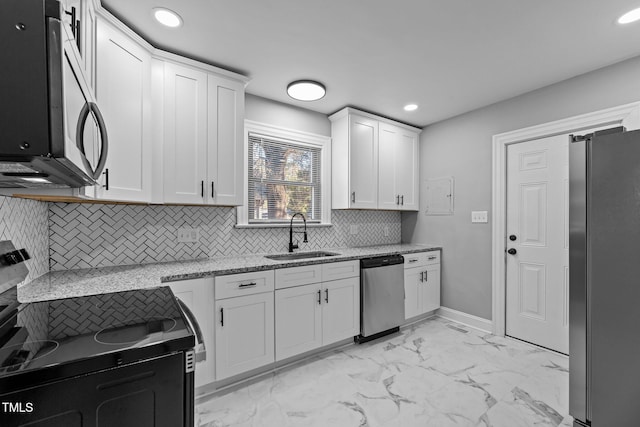 kitchen with white cabinetry, appliances with stainless steel finishes, light stone countertops, and sink