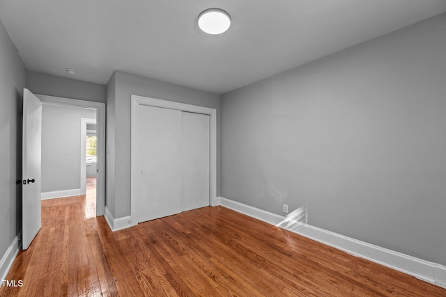 unfurnished bedroom featuring wood-type flooring and a closet