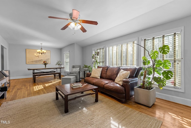 living room with hardwood / wood-style flooring and ceiling fan with notable chandelier