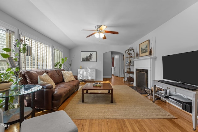 living room with lofted ceiling, hardwood / wood-style flooring, and ceiling fan