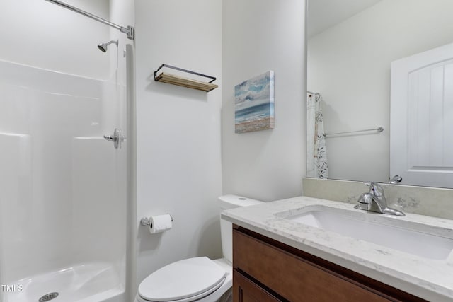 bathroom featuring a shower, vanity, and toilet