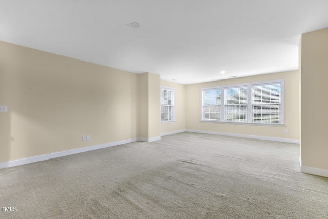 carpeted spare room featuring baseboards