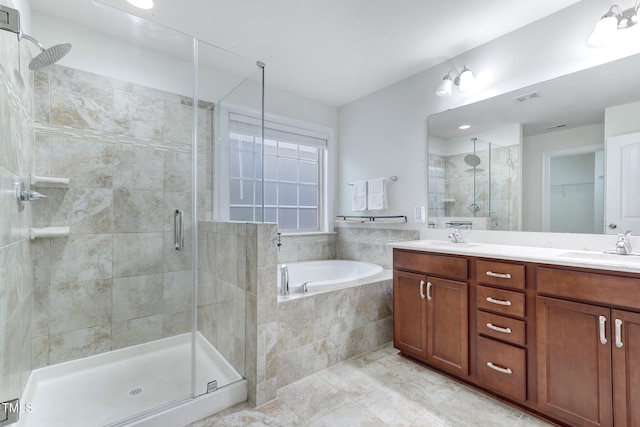 bathroom featuring a garden tub, a shower stall, visible vents, and a sink