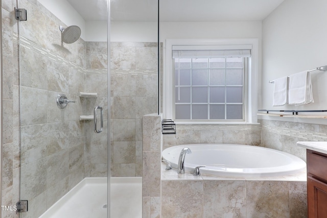 bathroom with a stall shower, vanity, and a bath