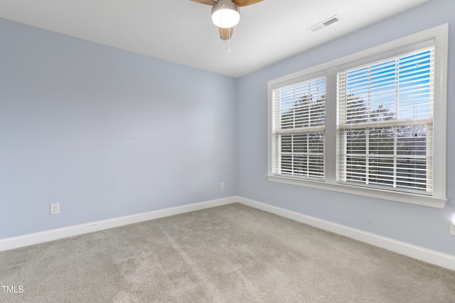 carpeted empty room with visible vents, ceiling fan, and baseboards