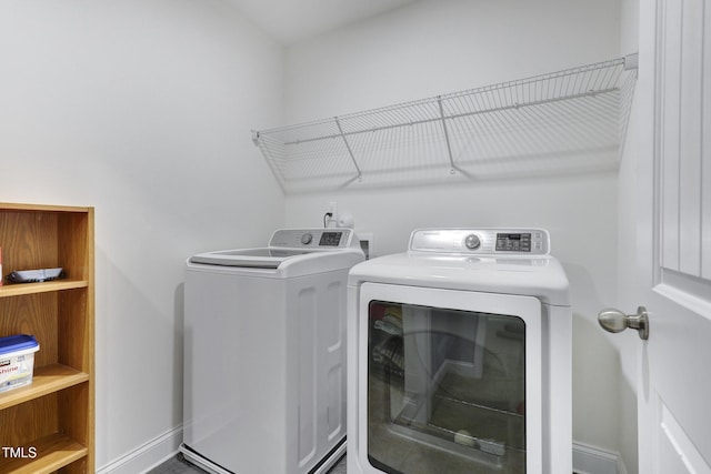 laundry room featuring laundry area, separate washer and dryer, and baseboards