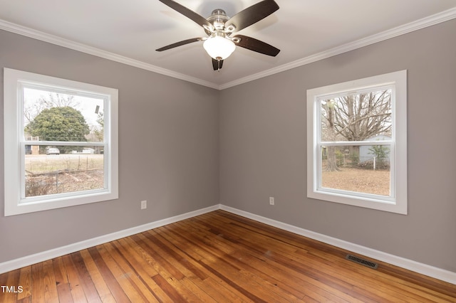 empty room with hardwood / wood-style floors, ceiling fan, and a healthy amount of sunlight