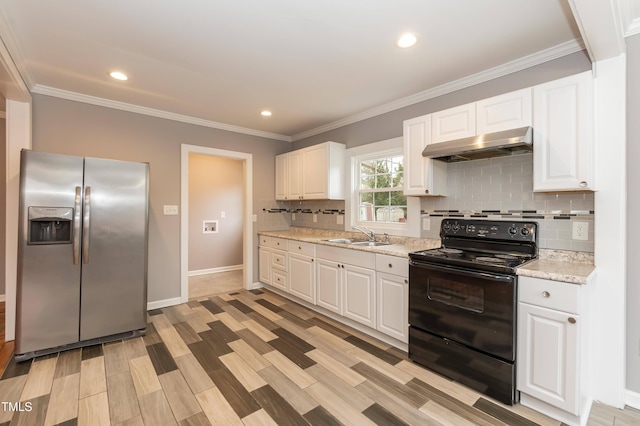 kitchen with black electric range, stainless steel fridge, white cabinets, and sink