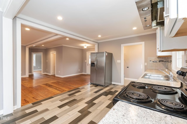 kitchen with stainless steel fridge with ice dispenser, sink, light hardwood / wood-style floors, and ornamental molding