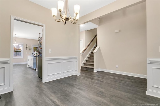 unfurnished dining area featuring dark hardwood / wood-style flooring and a chandelier