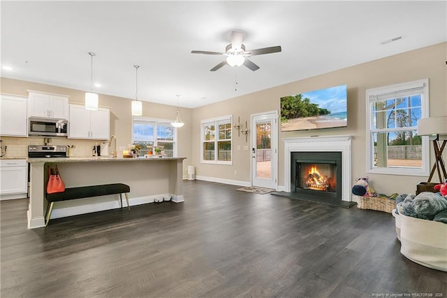 living room featuring ceiling fan, dark hardwood / wood-style flooring, and sink