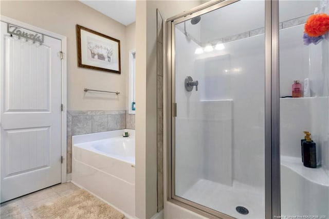 bathroom with tile patterned floors, separate shower and tub, and tile walls