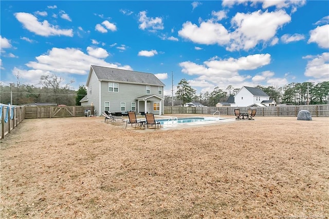 rear view of house featuring a fenced in pool