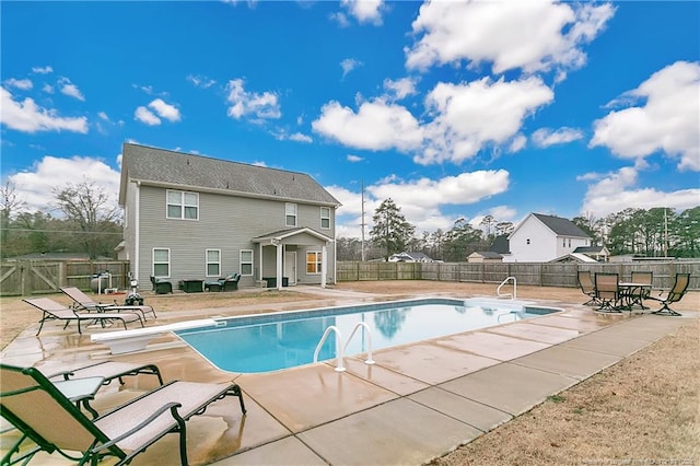 view of swimming pool featuring a diving board and a patio