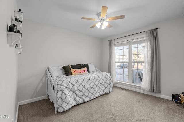 carpeted bedroom with baseboards, visible vents, and ceiling fan