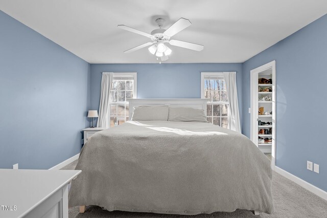 unfurnished bedroom featuring ceiling fan, multiple windows, carpet flooring, and baseboards