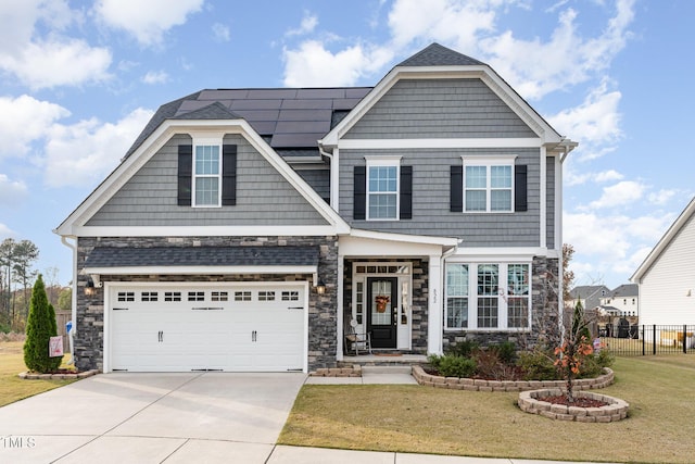 craftsman-style home featuring solar panels, a garage, and a front lawn