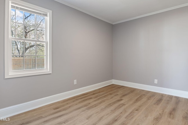 empty room with crown molding and light wood-type flooring