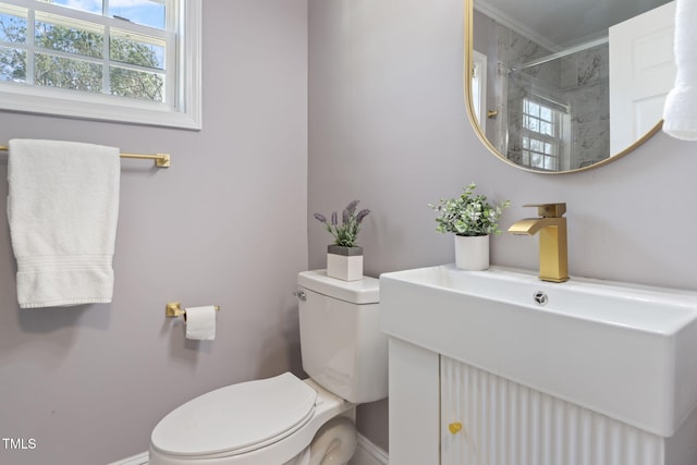 bathroom featuring toilet, vanity, and tiled shower