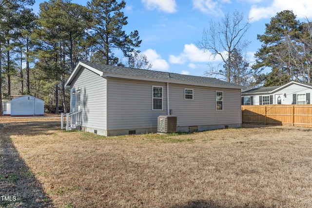 back of property with central AC and a yard