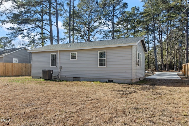 back of property featuring central AC unit and a yard